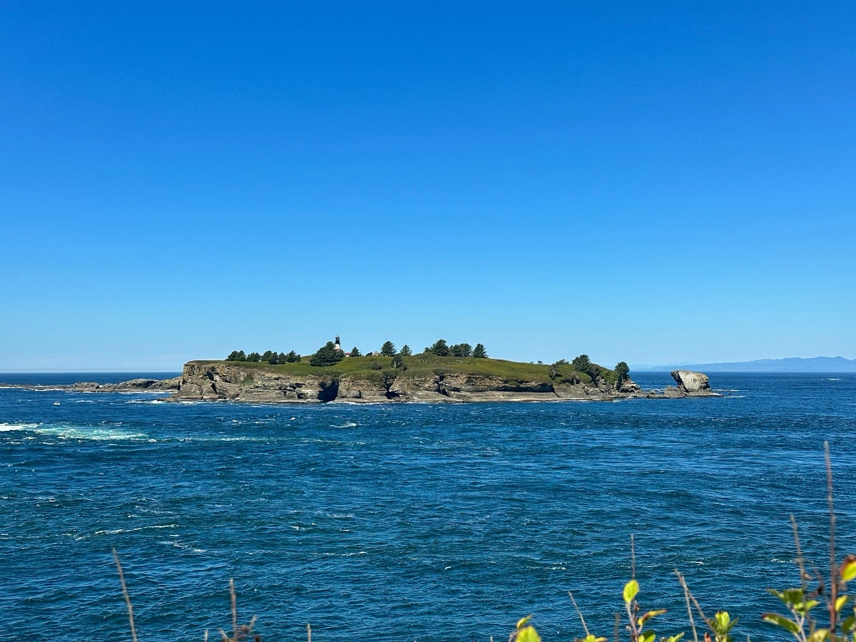 Tatoosh Island and its lighthouse amidst the rough blue waters of the Pacific Ocean