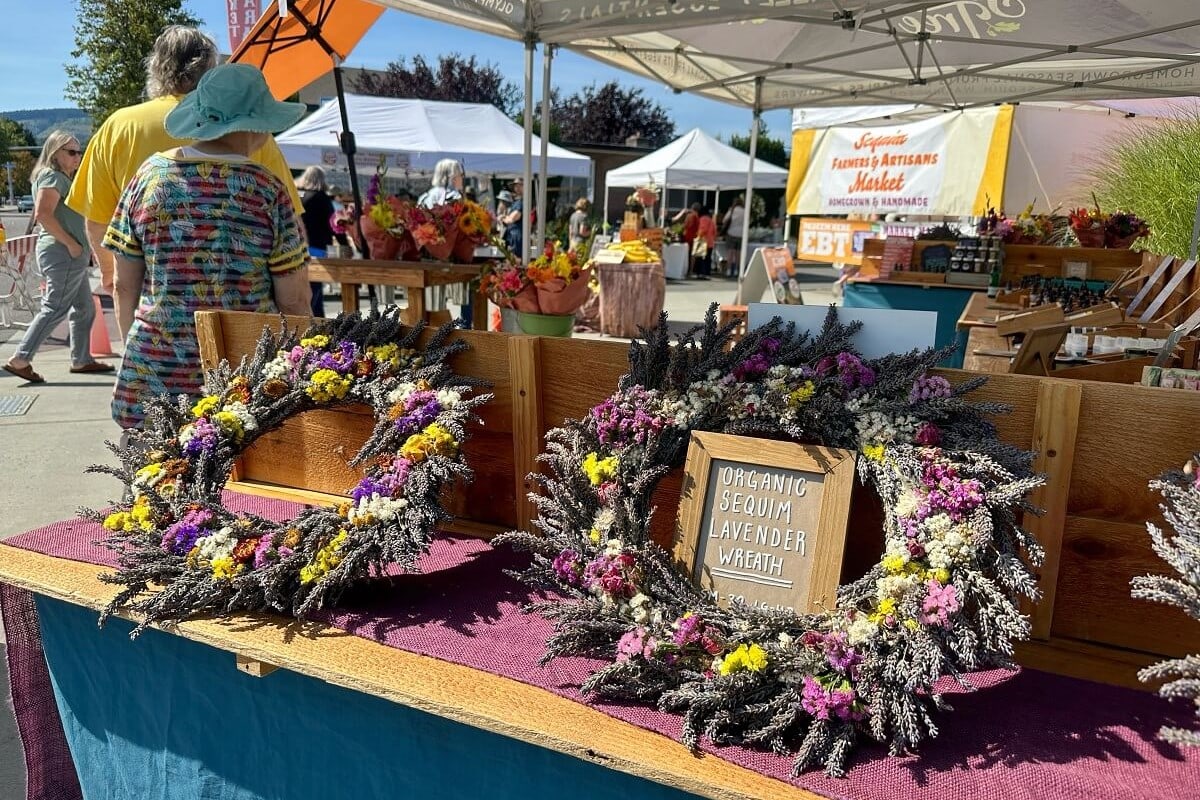 Lavender wreaths on display at a bustling farmers market in Sequim, one of the best towns near Olympic National Park