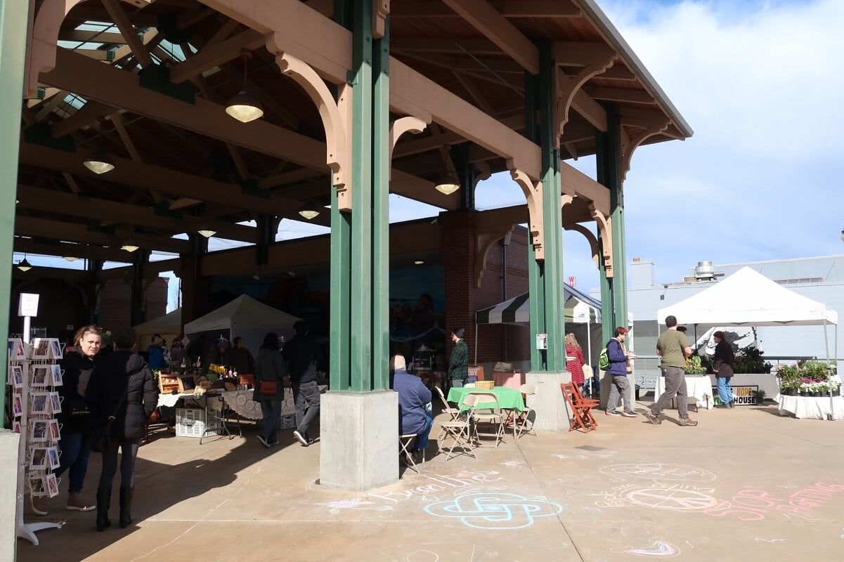 Port Angeles Farmers Market where vendors set up their tables to sell produce, cards, and other items to visitors perusing the open-air stalls.