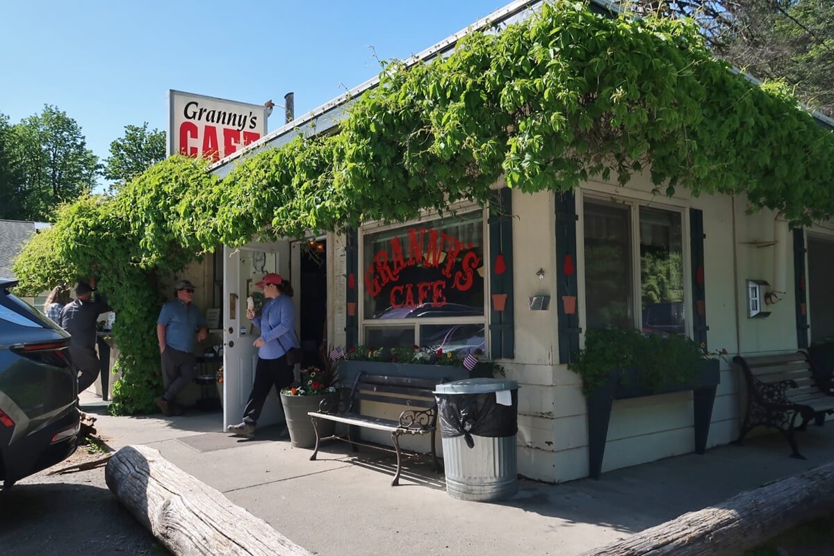 Granny’s Cafe off of Highway 101 covered in green vines with a sign reading “Granny’s Cafe” above the entrance and people standing outside.